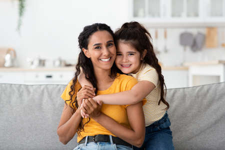 Mothers Day Concept. Happy Arab Woman And Little Daughter Embracing At Home