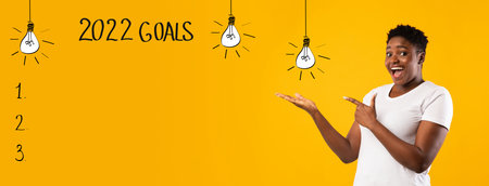 Excited plus size black woman pointing aside at empty space for 2022 goals list on orange background, banner designの写真素材