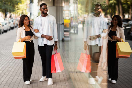 Beautiful black couple walking with shopping bagsの写真素材