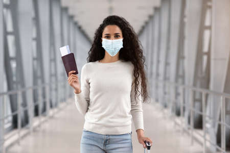 Pandemic Travels. Happy Young Woman In Protective Medical Mask Posing In Airportの写真素材