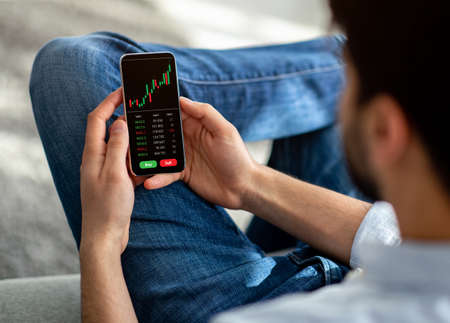 Arab guy using trading application on mobile phone, collage
