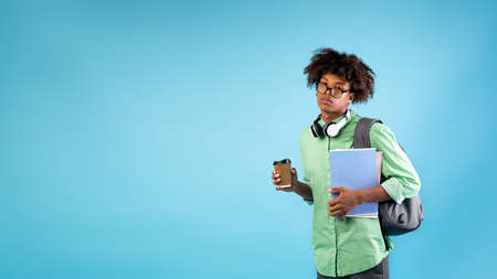 So tired. African american guy with notebooks, backpack and takeaway coffee, feeling fatigue from preparing for examsの写真素材