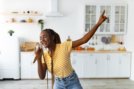 Young black woman having fun while cooking at kitchenの写真素材
