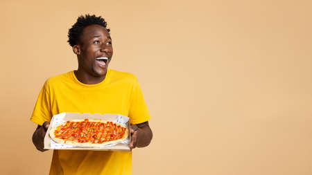 Food Delivery Concept. Excited Black Guy Holding Box With Tasty Italian Pizzaの写真素材