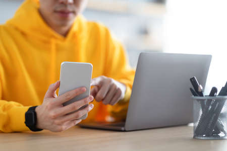 Closeup of man sitting at desk reading text message