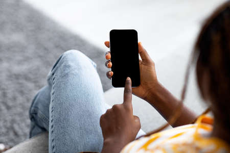 Top view of afro-american woman using smartphone with blank screenの写真素材