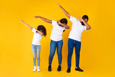 Portrait of black family dancing dabbing at studio
