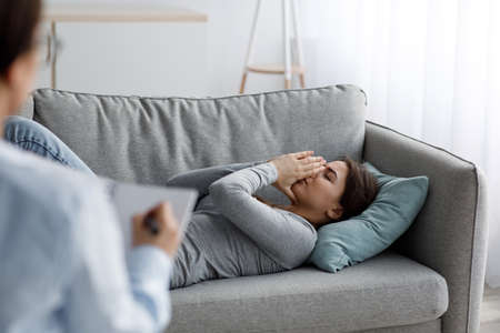 Sad unhappy young caucasian lady patient crying and talking about problems at visit