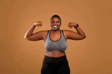 Chubby black woman posing and showing biceps musclesの写真素材