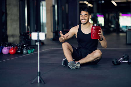 Handsome Arab Fitness Blogger Recording Video Review For Sport Nutrition At Gymの写真素材