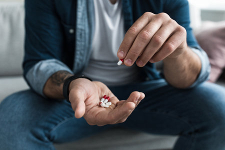 Colorful pharmaceutical medicine pills, narcotic drugs in capsules on palmの写真素材
