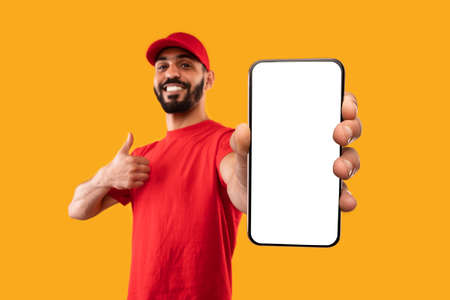Arabic Male Courier Showing Phone With Blank Screen, Studio Shotの写真素材