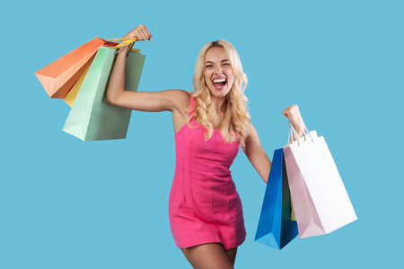 Yes. Cheerful lady holding shopping bags with new clothesの写真素材