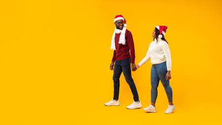 African Couple Wearing Santa Hats Standing Near Free Space, Studioの写真素材