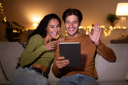 Happy Couple Makes Video Call Using Digital Tablet At Homeの写真素材