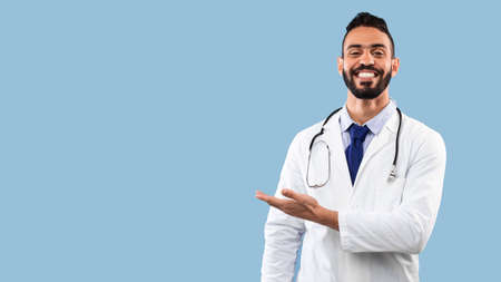 Happy Arabic Doctor Man Smiling Showing Copy Space, Blue Backgroundの写真素材
