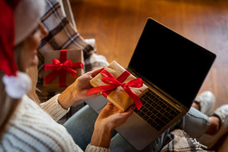 Happy Woman Holding Present Box Using Computerの写真素材