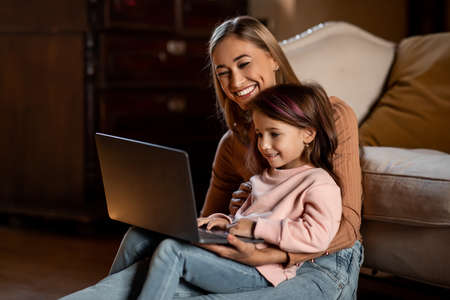 Portrait of happy woman and daughter using laptopの写真素材