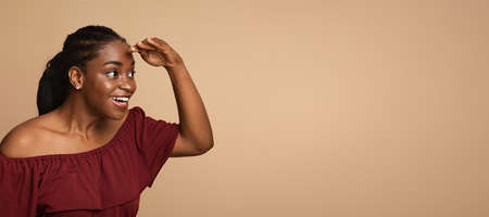 Curious african american young woman looking at somethingの写真素材