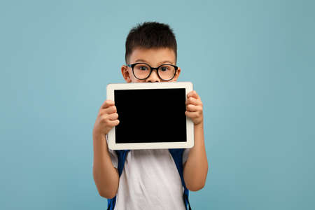 Distant Education. Asian Schoolboy Holding Digital Tablet With Blank Black Screenの写真素材