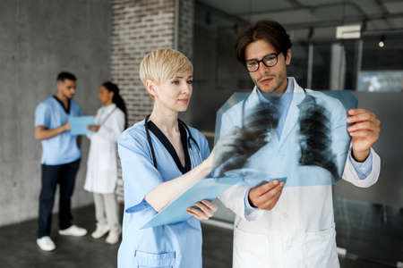 Two doctors man and woman looking at x-ray scan