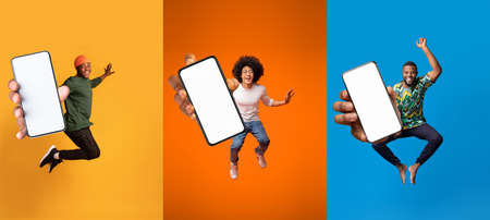 Joyful emotion excited millennial black men jumping and show device with blank screen, recommend websiteの写真素材