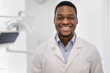 Dentistry Concept. Handsome Black Dentist Man Posing At Workplace In Modern Clinicの写真素材