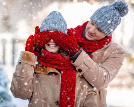 Handsome man making surprise for his woman, winter shotの写真素材