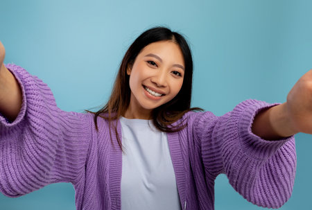 Photography concept. Portrait of asian woman taking selfie picture, point of view pov shot of smiling ladyの写真素材