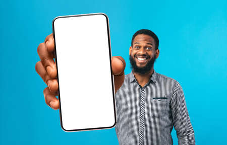 Cool Mobile App. Cheerful Black Man Showing Smartphone With Big White Screen