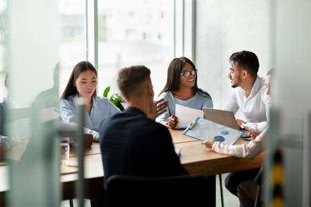 Cheerful Young Multiethnic Business Team Brainstorming Together During Corporate Meeting In Office