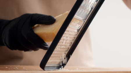 Unrecognizable Cook Grating Cheese On Grater Cooking In Kitchen, Closeupの写真素材