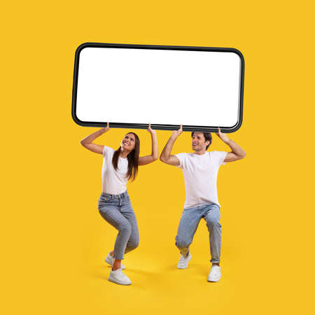 Couple holding heavy white empty smartphone screenの写真素材