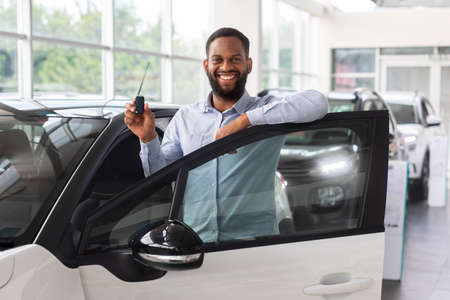 Buying Auto. Black Man With Keys In Hand Standing Near New Car
