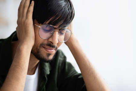 Indian guy touching his head, suffering from migraineの写真素材