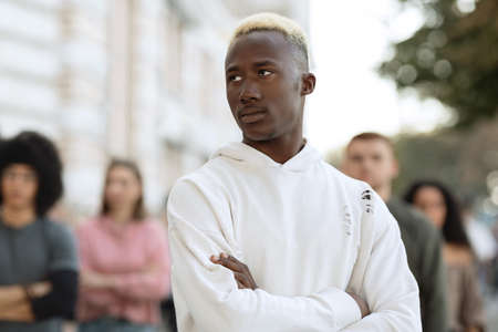 Confident black guy leader standing over multiracial group of millennialsの写真素材