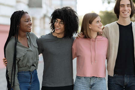 Multiracial group of cheerful millennials spending time togetherの写真素材