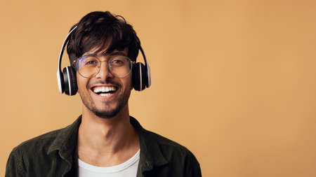 Laughing arabic guy enjoying brand new wireless headsetの写真素材