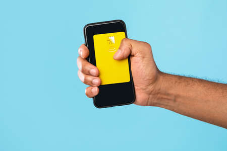 Online shopping, banking, electronic money. Cropped view of young black man holding credit card and mobile phone, mockupの写真素材