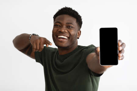 Cellphone with blank screen in young black man handの写真素材