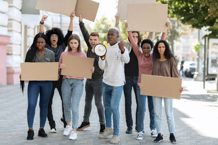 Motivated african american man with loudspeaker over crowdの写真素材