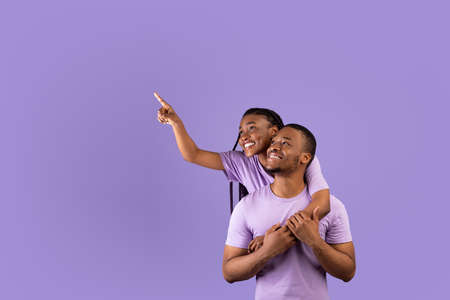 Smiling black couple pointing up at free copy spaceの写真素材