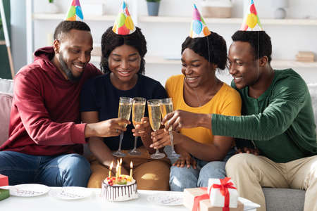 Joyful african american men and women celebrating birthday at homeの写真素材