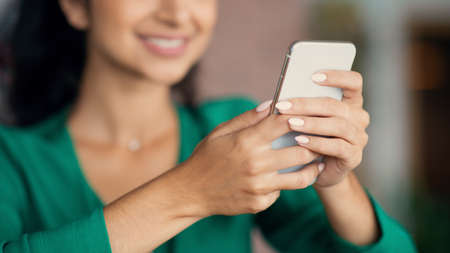 Unrecognizable woman having lunch break at cafe, using cellphoneの写真素材