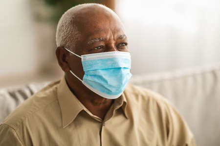 Sick Mature Patient Man Wearing Face Mask Looking Aside Indoorsの写真素材