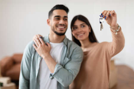 Happy couple showing keys of their apartment, selective focusの写真素材