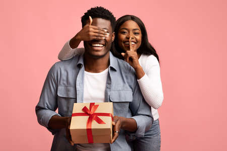 Loving african american woman making surprise for her man