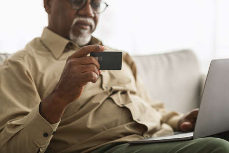 Black Man Holding Credit Card Shopping Online Using Laptop Indoorの写真素材