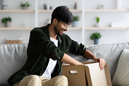 Cheerful middle eastern guy checking delivery package