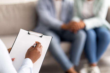 Closeup of black married couple and psychotherapist at office after effective session, selective focusの写真素材